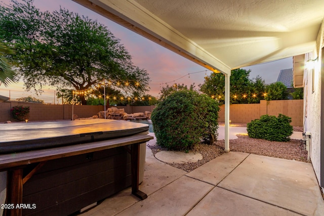 3152 N 83rd Pl, Scottsdale, AZ 85251 - patio terrace at dusk featuring a hot tub, a patio, and a fenced backyard