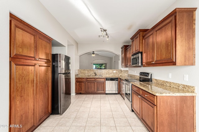 3152 N 83rd Pl, Scottsdale, AZ 85251 - kitchen featuring stainless steel appliances, light tile patterned floors, and brown cabinetry