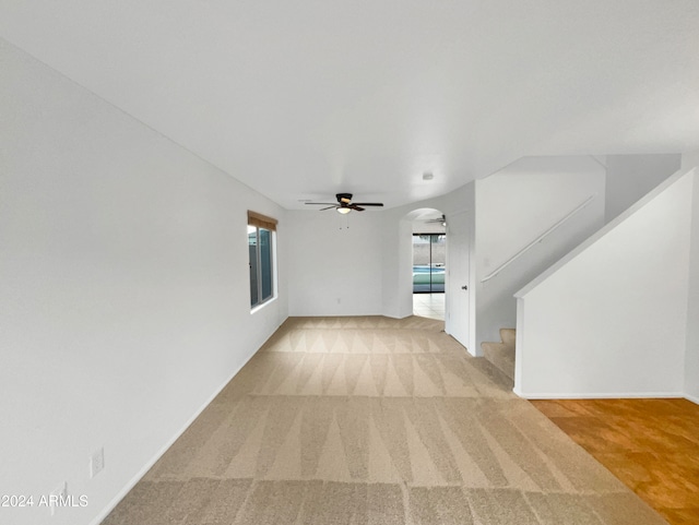 unfurnished living room with ceiling fan and light colored carpet