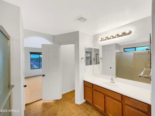 bathroom featuring vanity and a shower with shower door