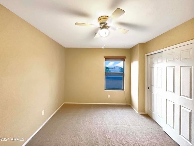 unfurnished bedroom with carpet, a closet, and ceiling fan