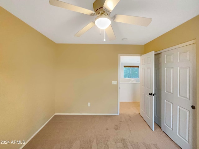 interior space featuring light carpet, a closet, and ceiling fan