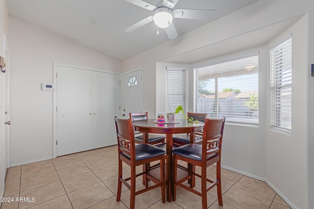 tiled dining space with ceiling fan and vaulted ceiling