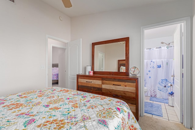 bedroom with ensuite bathroom, light carpet, and ceiling fan