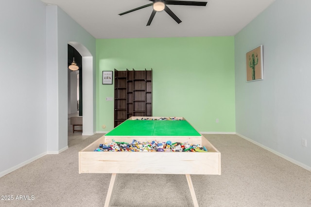 rec room with ceiling fan, arched walkways, carpet floors, and baseboards