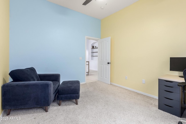 living area with light carpet, a ceiling fan, and baseboards
