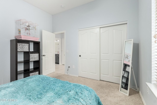 carpeted bedroom featuring a closet and baseboards