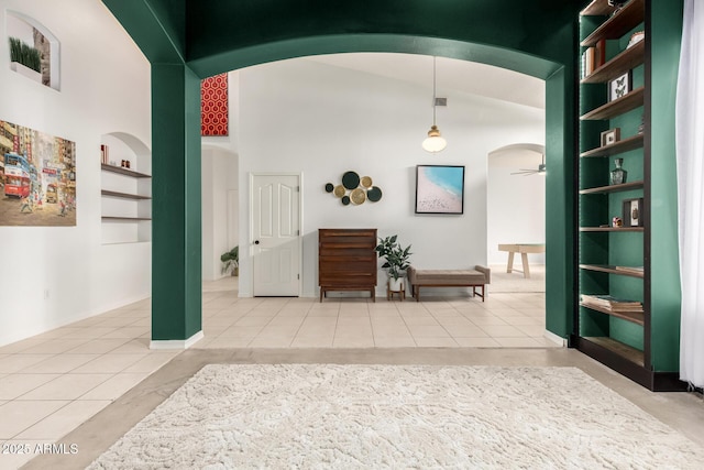 corridor with arched walkways and tile patterned floors