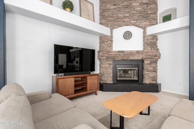 carpeted living area with a stone fireplace