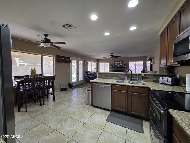 kitchen featuring appliances with stainless steel finishes, a peninsula, visible vents, ceiling fan, and a sink