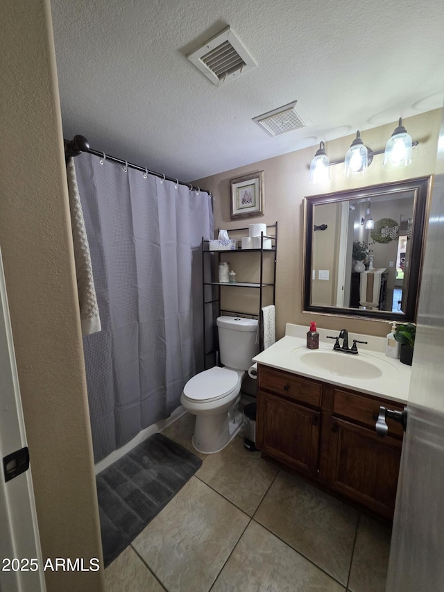 bathroom with toilet, vanity, tile patterned flooring, and visible vents