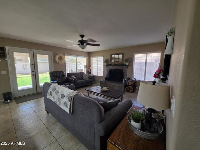 living room featuring french doors, light tile patterned floors, a ceiling fan, and a fireplace with raised hearth