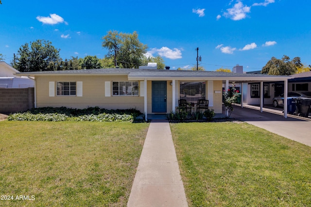 ranch-style house featuring covered porch, a front lawn, and a carport