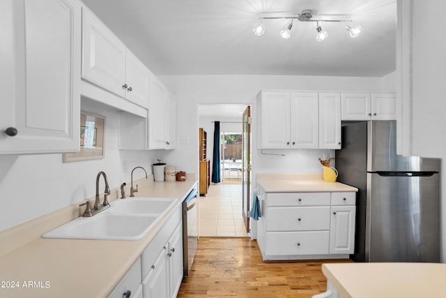 kitchen featuring sink, stainless steel appliances, white cabinetry, and light wood-type flooring