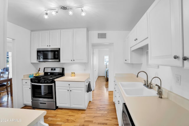 kitchen with sink, stainless steel appliances, light hardwood / wood-style flooring, and white cabinets