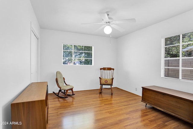 living area featuring ceiling fan, light hardwood / wood-style floors, and plenty of natural light