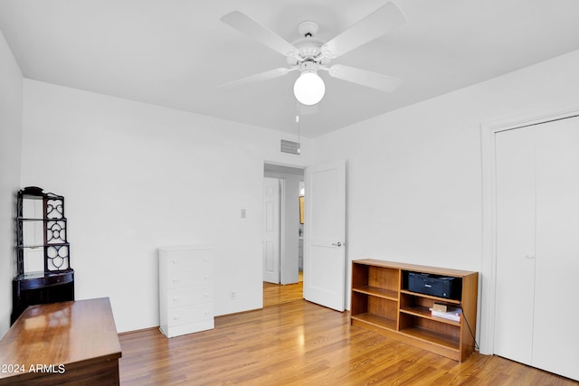 unfurnished bedroom with ceiling fan, a closet, and hardwood / wood-style floors