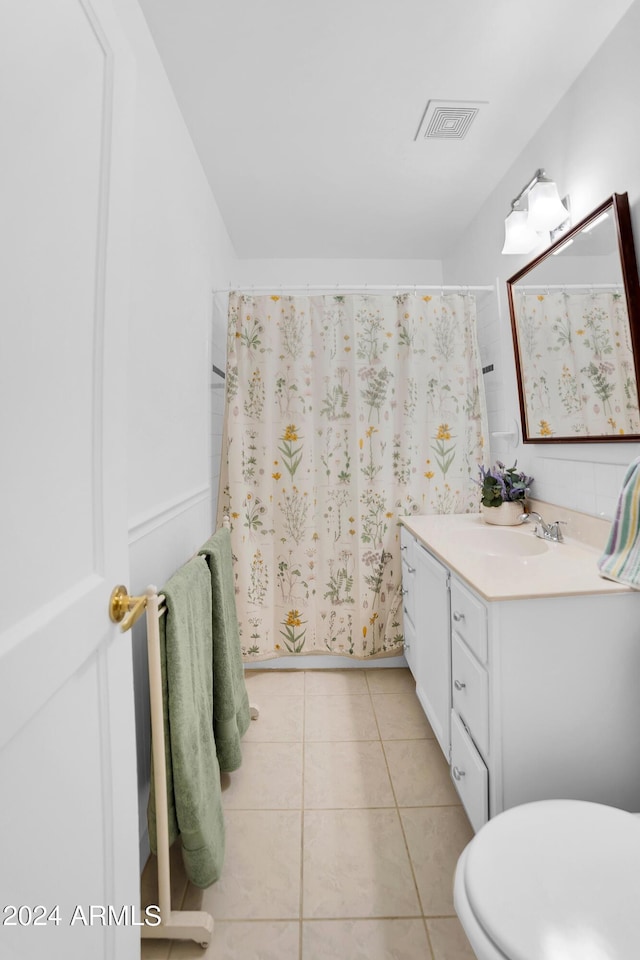 bathroom with toilet, vanity, tile patterned floors, and curtained shower