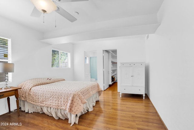 bedroom with ceiling fan, a spacious closet, hardwood / wood-style floors, and a closet