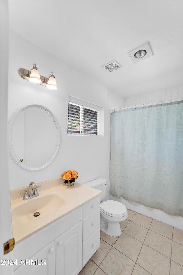 bathroom featuring walk in shower, vanity, tile patterned floors, and toilet