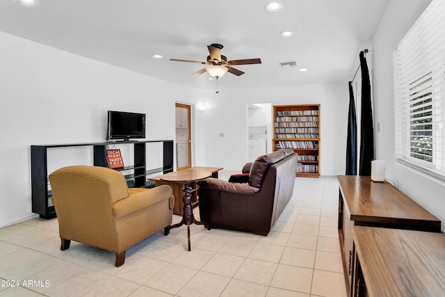 living room with washer / dryer, light tile patterned flooring, and ceiling fan