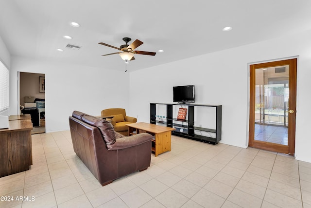 living room featuring light tile patterned floors, ceiling fan, and a healthy amount of sunlight