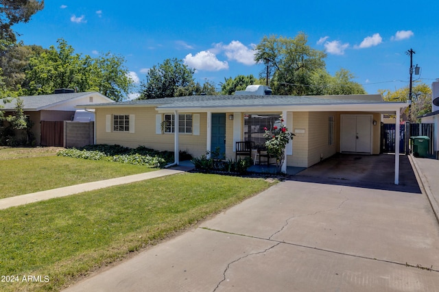 ranch-style home featuring a porch, a carport, and a front lawn