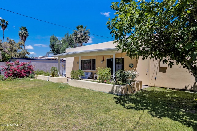 rear view of house featuring a lawn