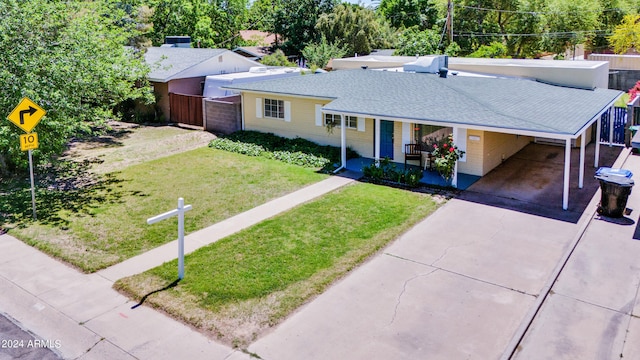 single story home with covered porch, a carport, and a front lawn