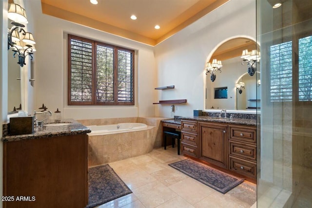 bathroom with two vanities, a sink, a tile shower, and a garden tub