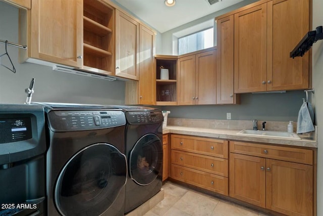 washroom with cabinet space, a sink, and washer and clothes dryer