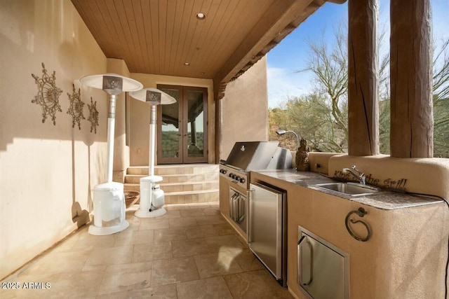 view of patio with an outdoor kitchen, french doors, area for grilling, and a sink