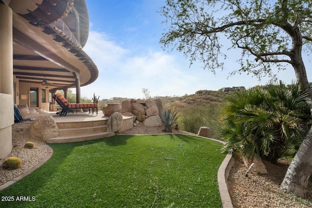 view of yard featuring a ceiling fan and a patio area