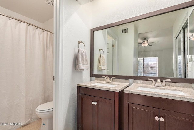 full bath with a ceiling fan, vanity, toilet, and curtained shower