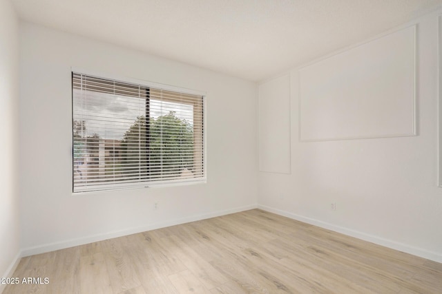 unfurnished room featuring wood finished floors and baseboards