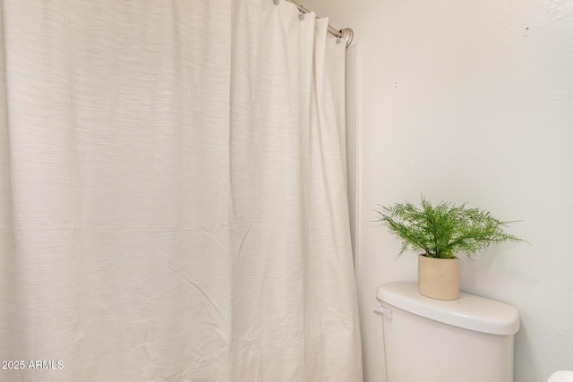 full bathroom with toilet and curtained shower