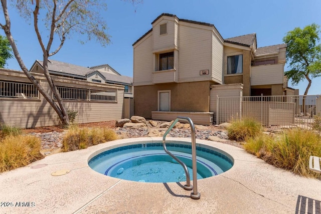 view of pool featuring an in-ground hot tub and fence