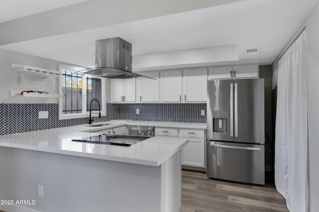 kitchen with dishwasher, white cabinets, island exhaust hood, kitchen peninsula, and stainless steel refrigerator with ice dispenser