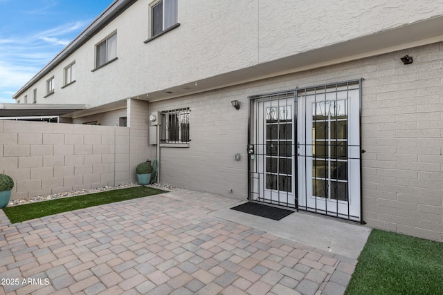 view of exterior entry featuring a patio