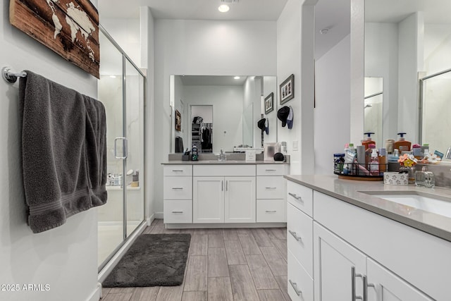 bathroom with a shower with door and vanity