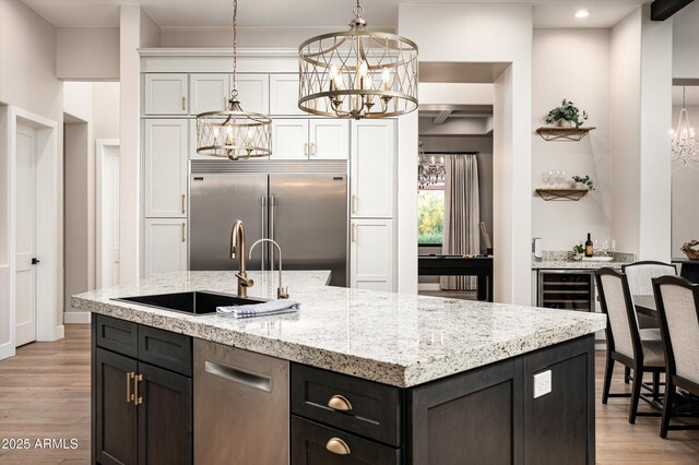 kitchen with a chandelier, appliances with stainless steel finishes, a sink, white cabinetry, and recessed lighting