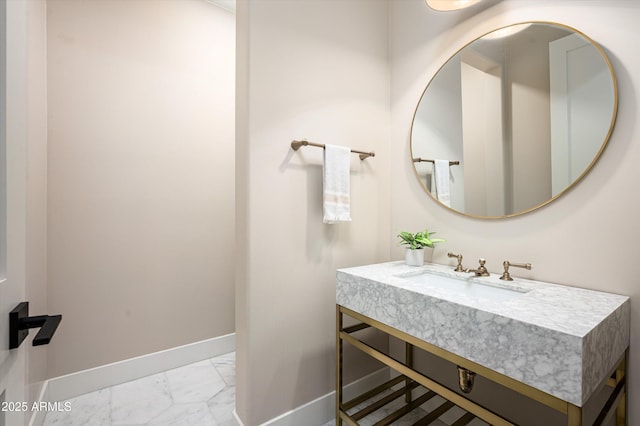 bathroom with marble finish flooring, baseboards, and vanity