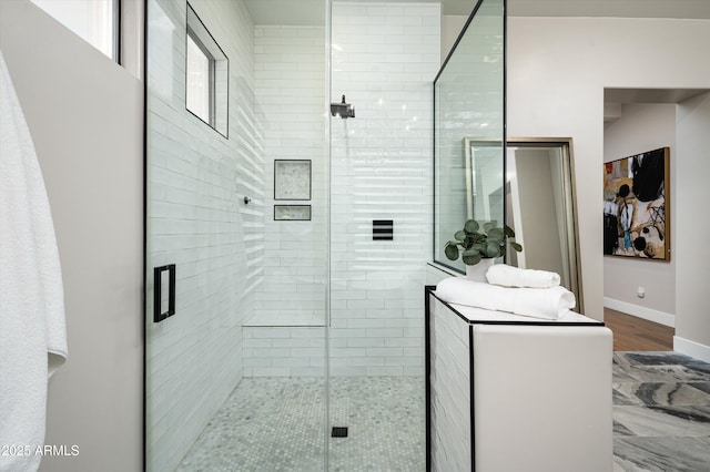 bathroom featuring a stall shower and baseboards