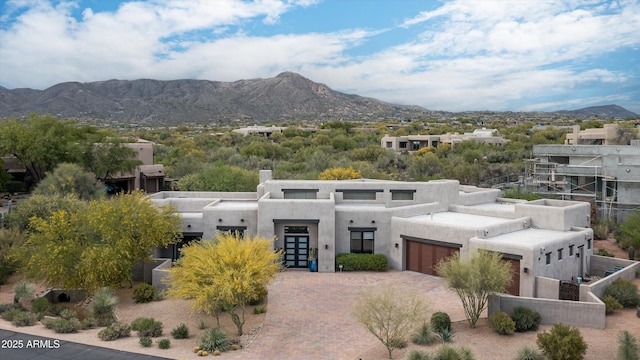 view of front of home with a chimney, an attached garage, and a mountain view