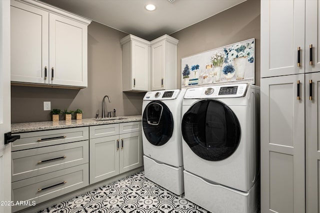 laundry area with independent washer and dryer, cabinet space, and recessed lighting