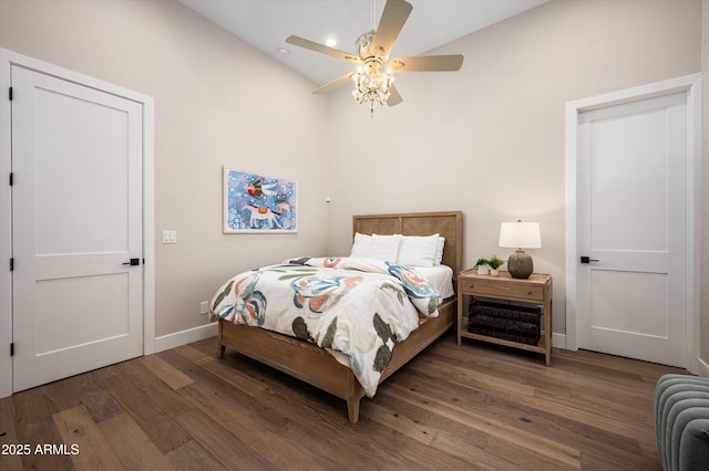bedroom with lofted ceiling, wood finished floors, baseboards, and a ceiling fan