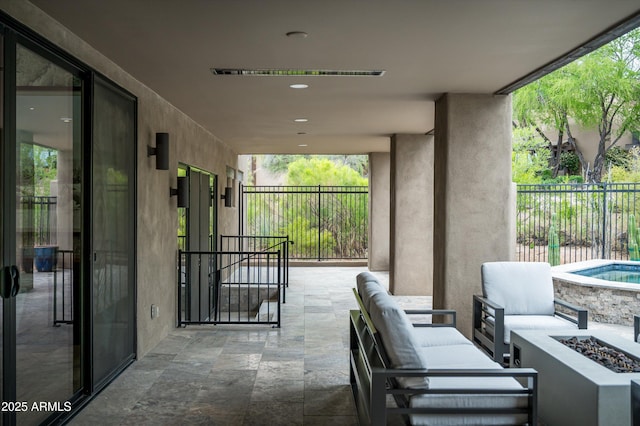 view of patio with an outdoor living space with a fire pit and fence