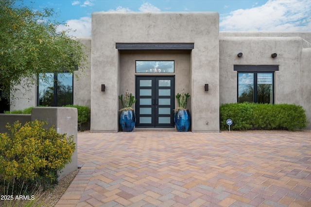 entrance to property with french doors and stucco siding