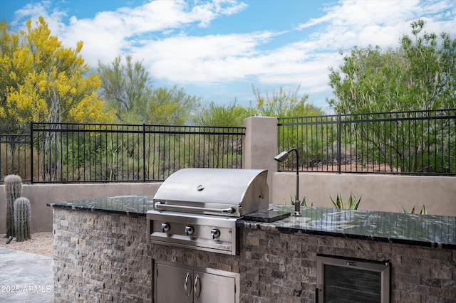 view of patio featuring area for grilling, wine cooler, and fence