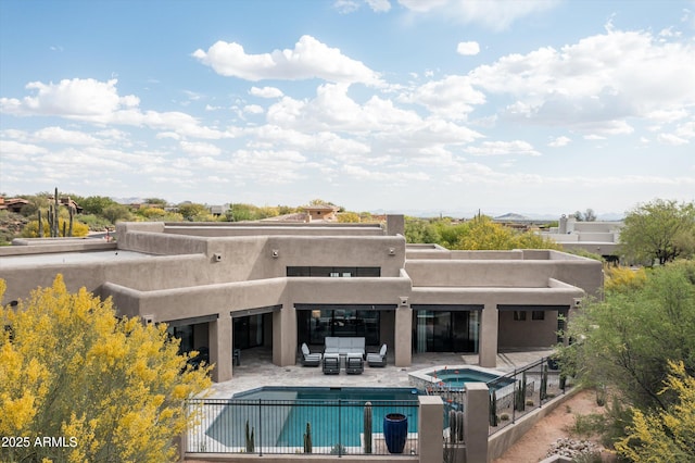 back of house with a patio area, stucco siding, a pool with connected hot tub, and an outdoor hangout area